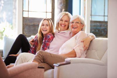 multi-generations of woman smiling on couch l dentist farmington nm